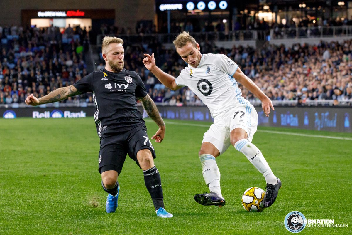 September 25, 2019 - Saint Paul, Minnesota, United States - Minnesota United defender Chase Gasper (77) dribbles the ball by Sporting KC forward Johnny Russell (7) during a match at Allianz Field. 
