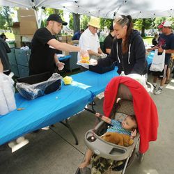 Randi Gonzales and her son, Elario, get some food as Subway serves a free lunch to nearly 1,100 needy people at Pioneer Park in Salt Lake City on Wednesday, June 5, 2013. Local Subway restaurants and the Rescue Mission of Salt Lake teamed up to raise awareness of the problems facing Salt Lake’s homeless and low-income families.