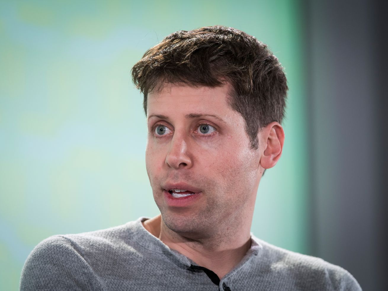 Sam Altman is pictured turning his head and talking.