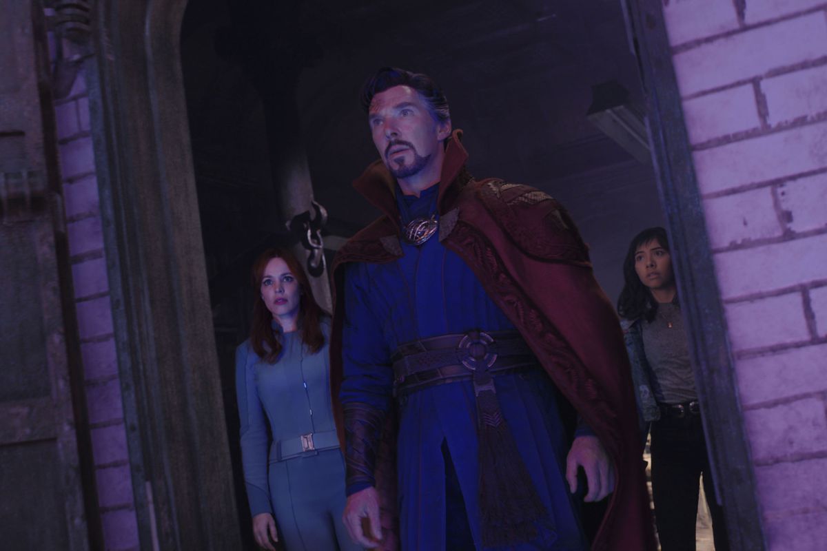 Rachel McAdams as Dr. Christine Palmer, Benedict Cumberbatch as Dr. Stephen Strange, and Xochitl Gomez as America Chavez stand in a brick doorway in Doctor Strange and the Multiverse of Madness.
