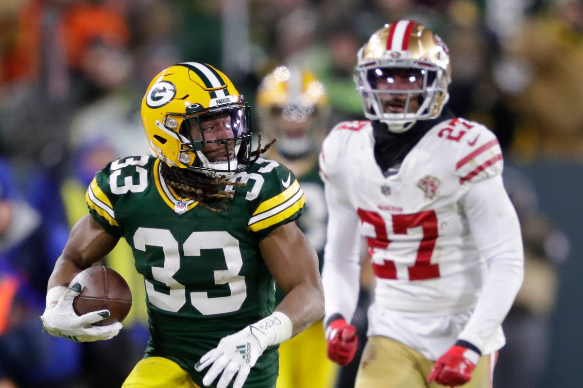 Green Bay Packers running back Aaron Jones (33) breaks away on a long reception against San Francisco 49ers defensive back Dontae Johnson (27) in the second quarter during their NFL divisional round football playoff game Saturday January 22, 2022, at Lambeau Field in Green Bay,&nbsp;