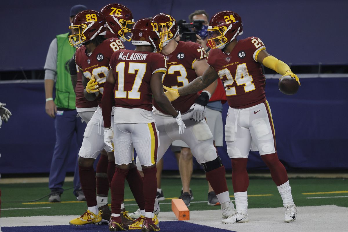 Antonio Gibson of the Washington Football Team celebrates with Terry McLaurin, Chase Roullier and Morgan Moses after rushing for a 23-yard touchdown during the fourth quarter of a game against the Dallas Cowboys at AT&amp;T Stadium on November 26, 2020 in Arlington, Texas.