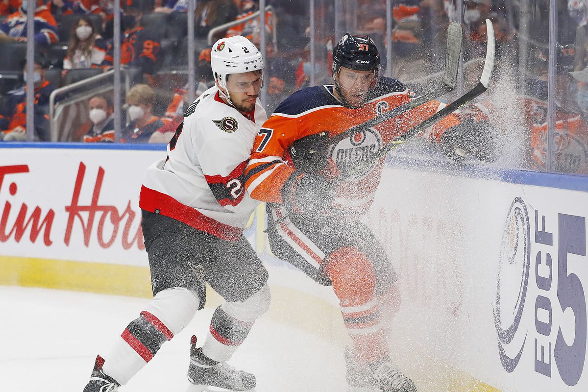 Jan 15, 2022; Edmonton, Alberta, CAN; Ottawa Senators defensemen Artem Zub (2) and Edmonton Oilers forward Connor McDavid (97) battle along the boards for a loose puck during the third period at Rogers Place.