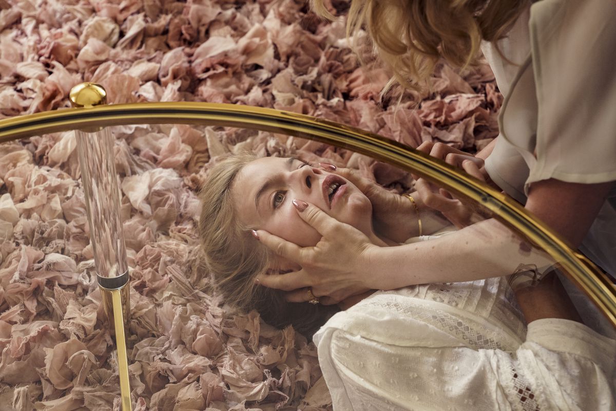 Two blonde figures fight to hatch on a pastel pink carpet.