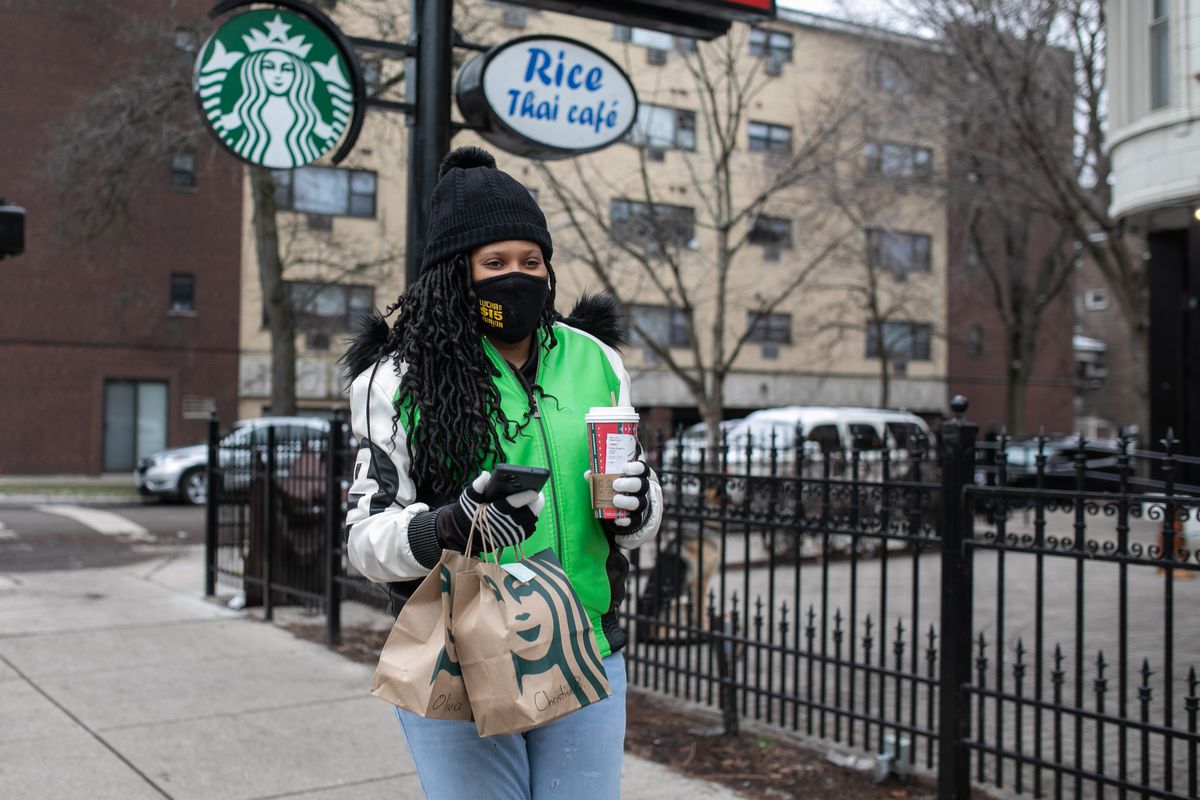 Ieshia Townsend, a food delivery worker who said she left her job at McDonald’s because of stressful working conditions, walks with a bag of food that she will deliver to a customer in the Rogers Park neighborhood.