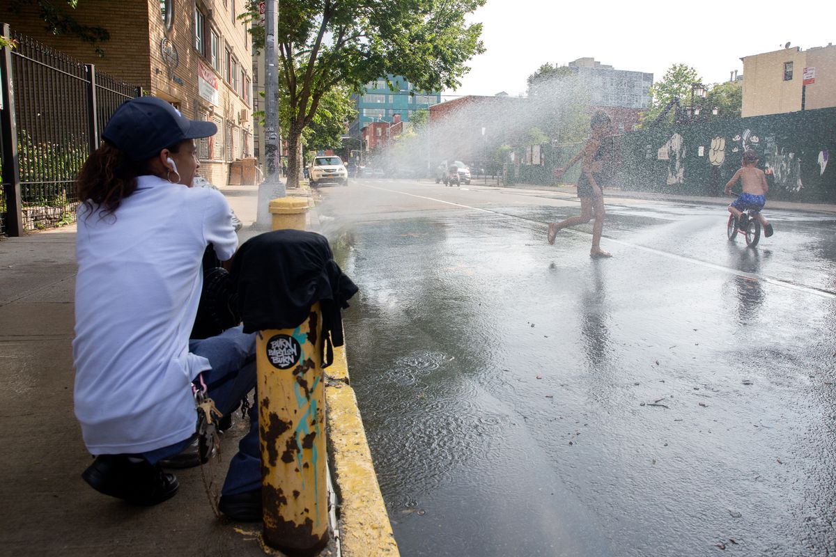 Tonya Gonzalez helps kids cool down on an open street in Williamsburg during the coronavirus outbreak, July 17, 2020.