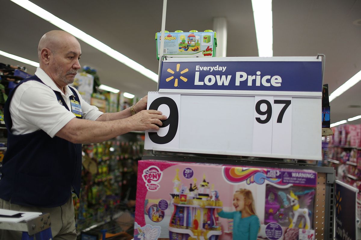 Walmart employee changes price on indoor sign.