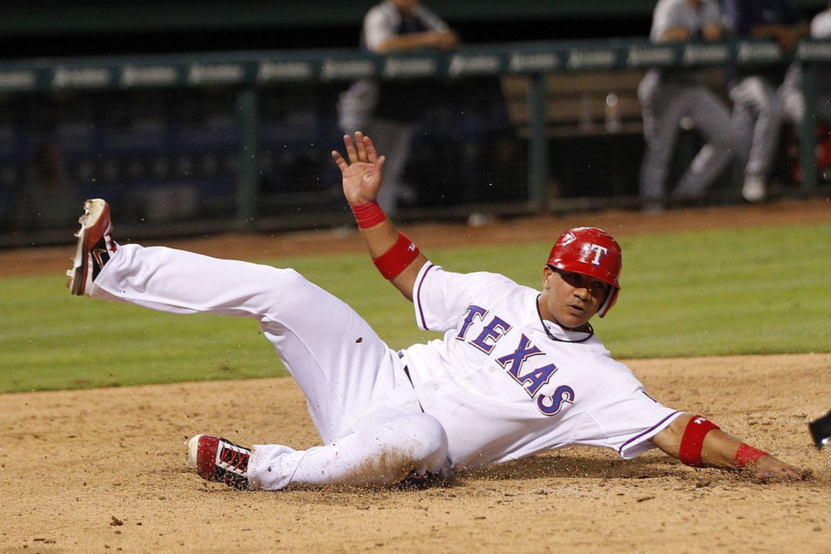 ARLINGTON, TX - MAY 30: Alberto Gonzalez #14 of the Texas Rangers slides into home in the sixth inning against the Seattle Mariners  at Rangers Ballpark in Arlington on May 30, 2012 in Arlington, Texas. (Photo by Rick Yeatts/Getty Images)