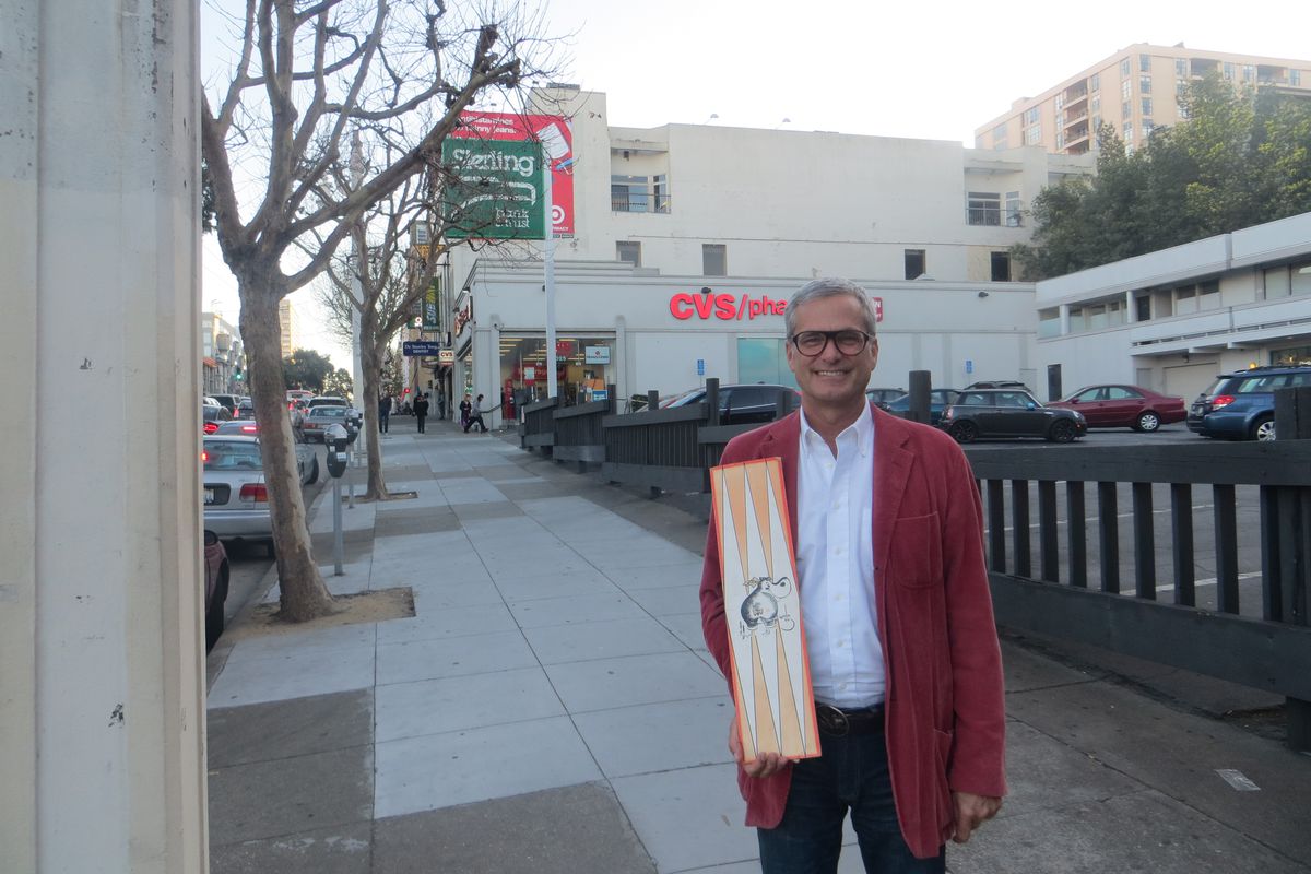 Mark Ritchie with a Hippo burger menu, outside the restaurant's former home (now a CVS).