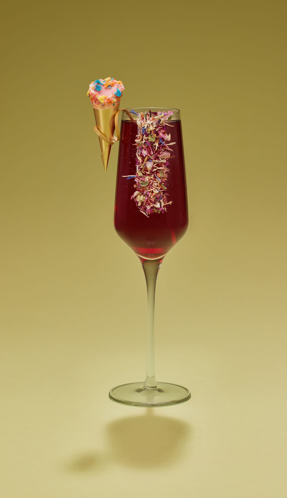 A red cocktail with petals.