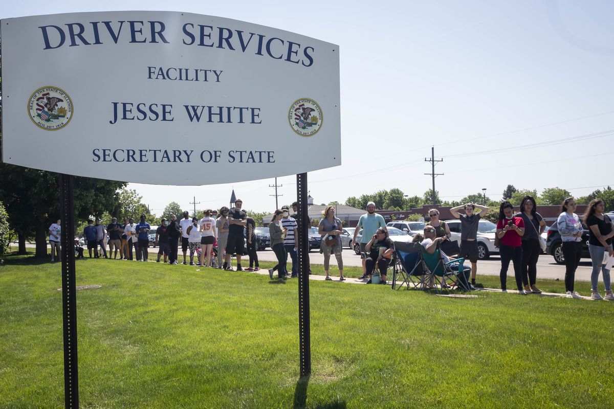 People wait in long lines to use the Secretary of State Driver Services facility in Naperville in June. All Illinois facilities will shut down in early January due to a spike in COVID-19 cases.