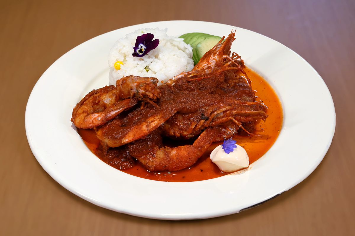A plate of large shrimp in a red sauce.