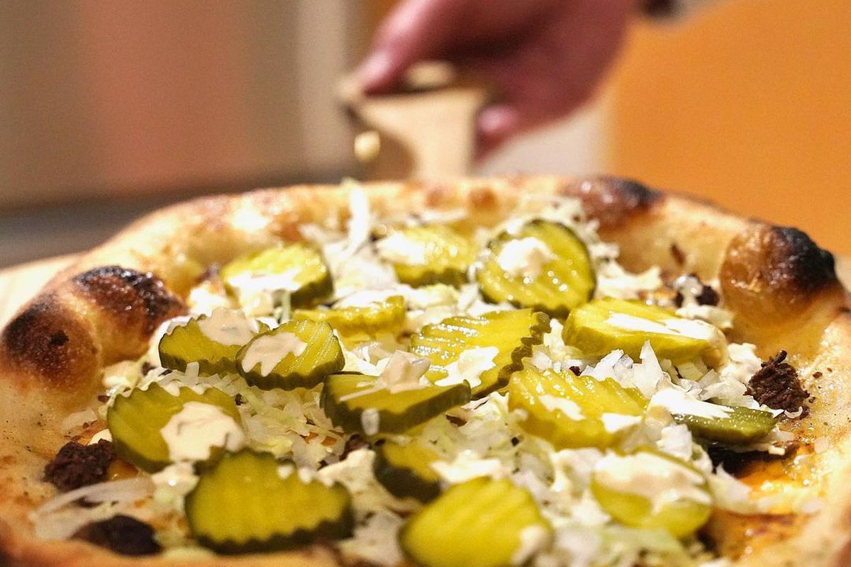 A pizza topped with pickles
