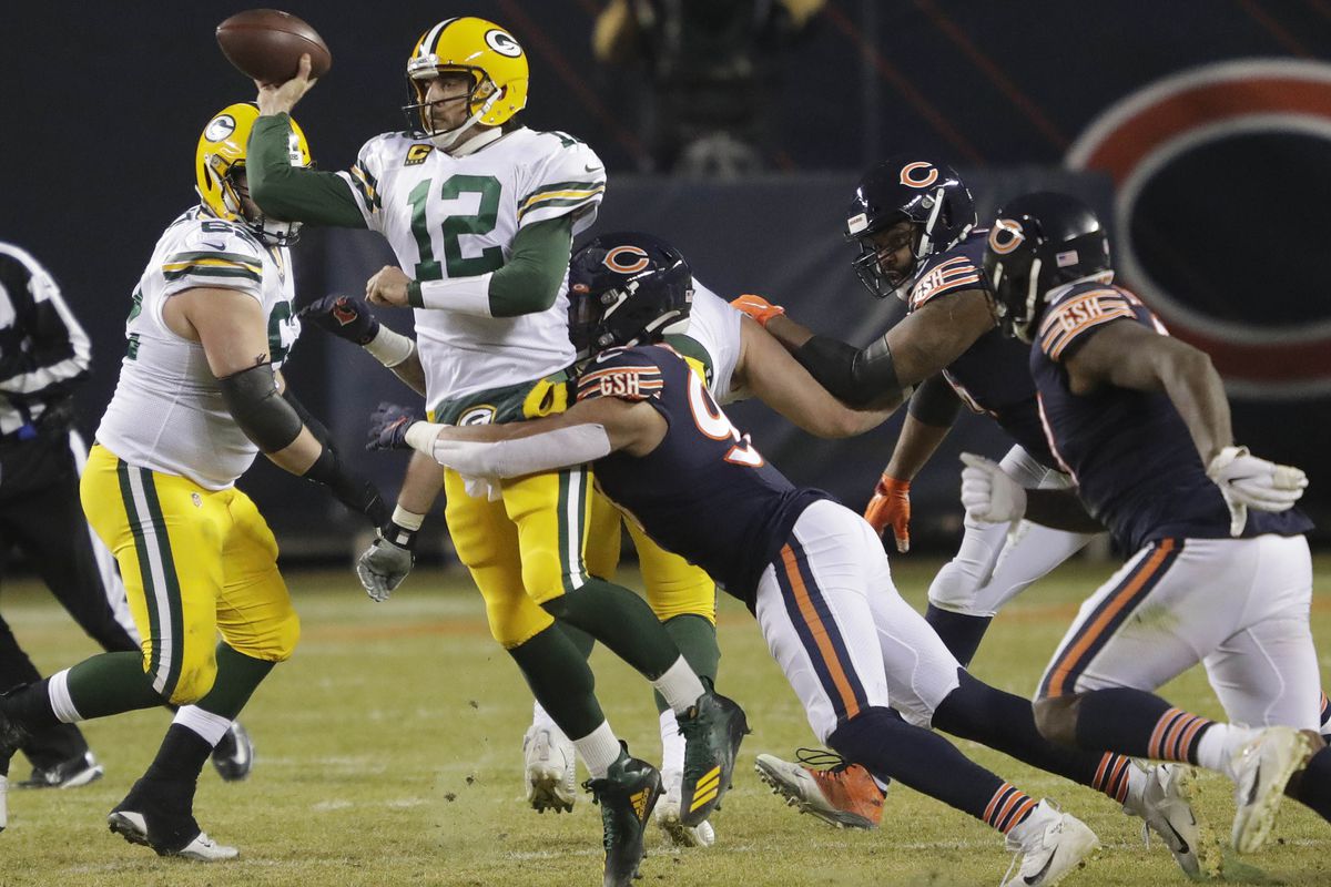 Green Bay Packers quarterback Aaron Rodgers (12) passes the ball under pressure from Chicago Bears linebacker Trevis Gipson (99) during their football game Sunday, January 3, 2021, at Soldier Field in Chicago, Ill.