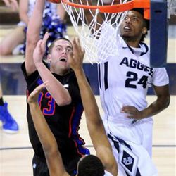 Boise State's David Wacker shots as Utah State's JoJo McGlaston (24) and Elston Jones defend during an NCAA college basketball game, Tuesday, Feb. 3, 2015, in Logan, Utah. (AP Photo/Herald Journal, John Zsiray)