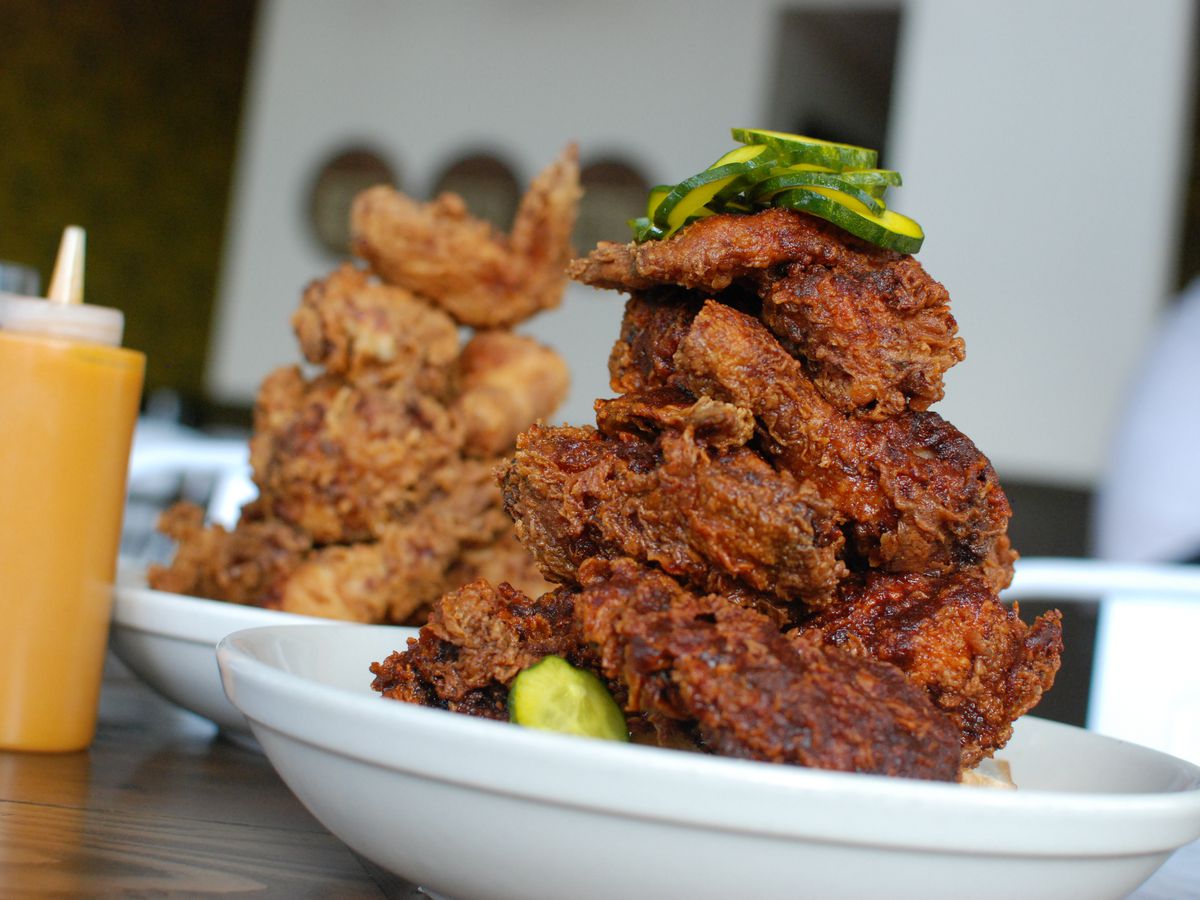 Two plates with towers of Tennessee hot and Southern fried chicken.