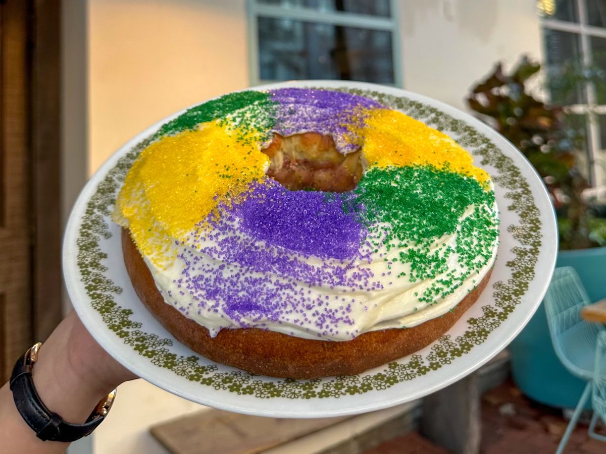 A person holds a plate of King Cake in front of Josephine’s entrance.