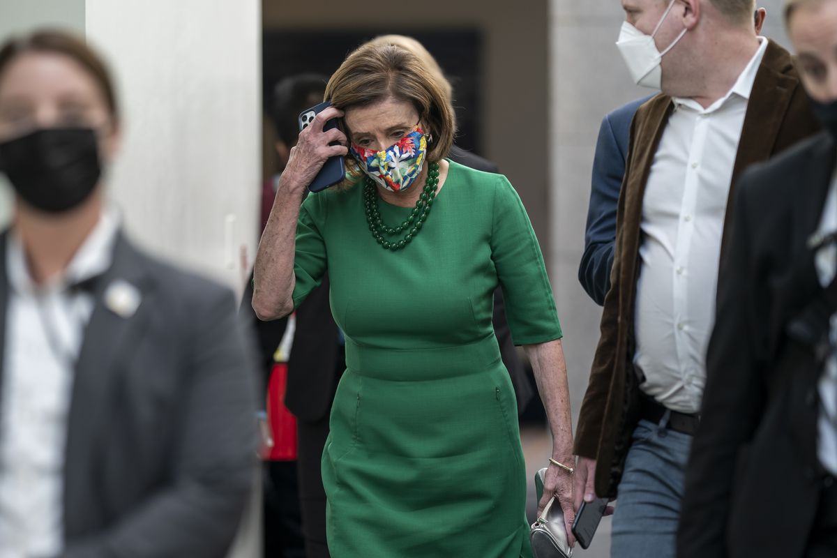 Speaker of the House Nancy Pelosi, D-Calif., is accompanied by staff and security as she rushes to a Democratic Caucus meeting on Wednesday.