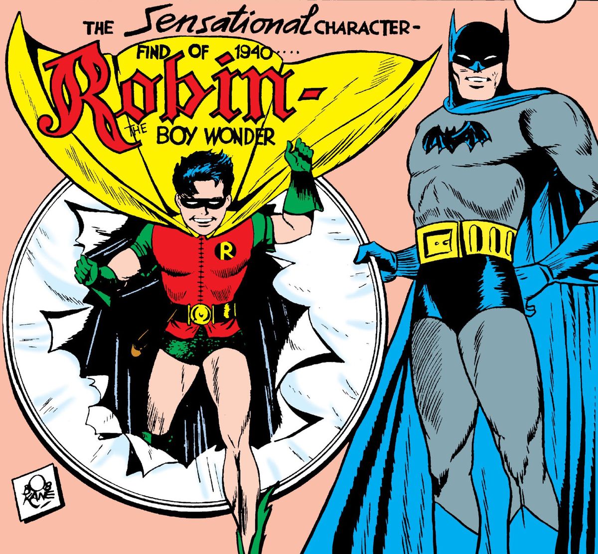 Batman holds a paper covered hoop, as Robin bursts out of it, on the cover of Detective Comics #38, DC Comics (1940). 