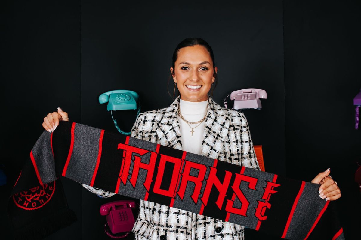 Izzy D’Aquila poses with her Thorns scarf after being drafted #12 in the first round by Portland. 