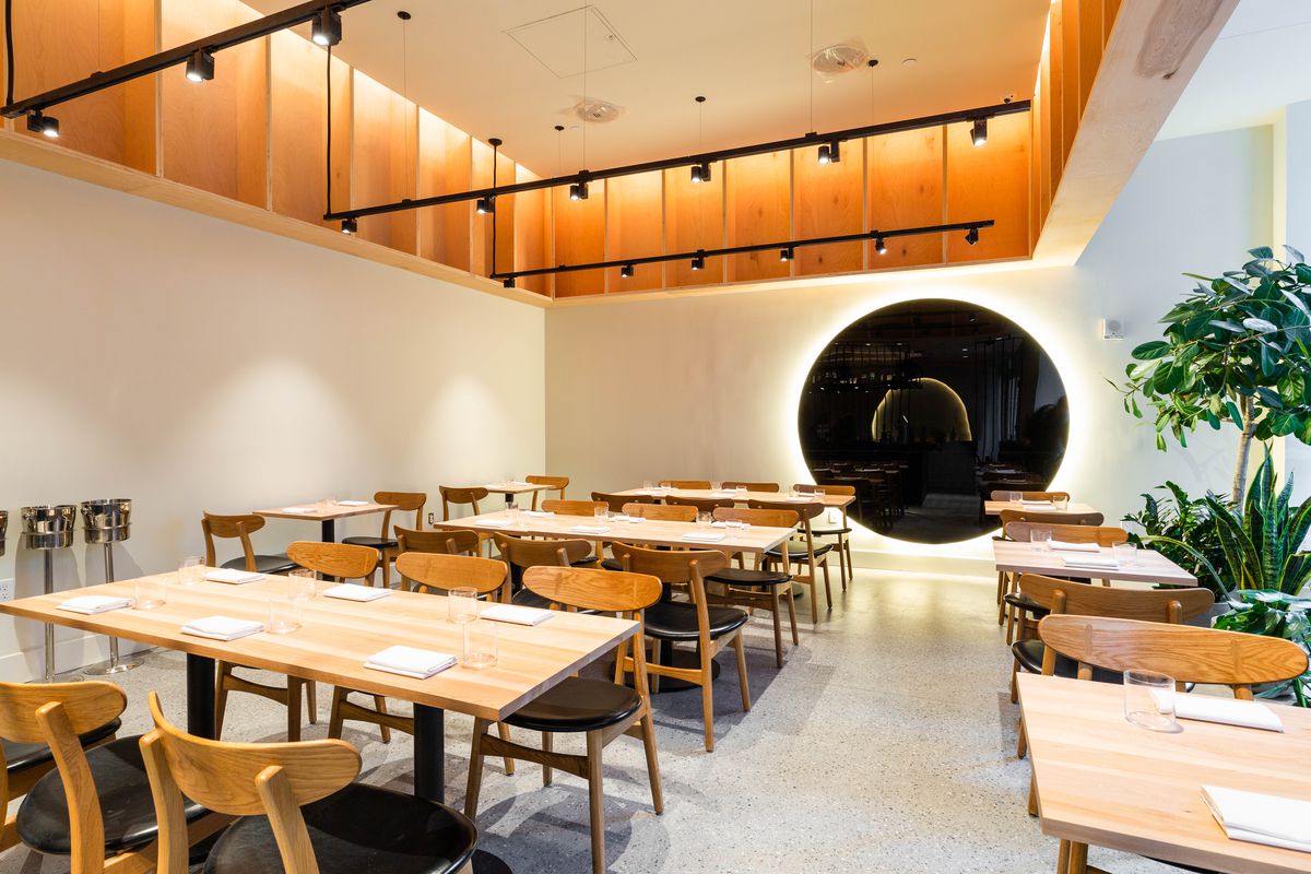The golden lit interior of a restaurant with a black circle adoring the back wall