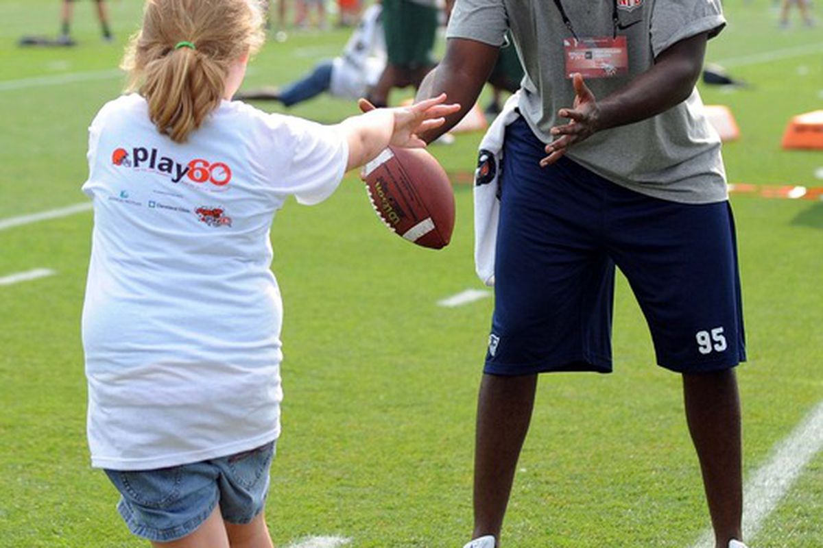 June 29, 2012; Berea, OH USA: New England Patriots defensive end Chandler Jones catches a ball from a young girl during the AFC rookie symposium at the Cleveland Browns Training Facility.  Mandatory Credit: Eric P. Mull-USPRESSWIRE