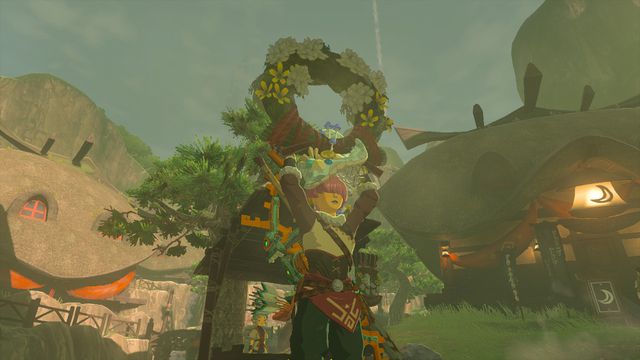 Link holds a Ring Garland above his head, standing triumphantly in The Legend of Zelda: Tears of the Kingdom.