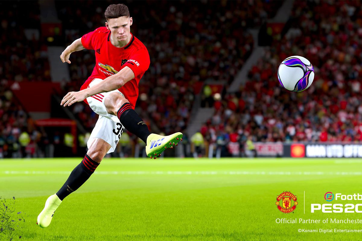 A player for Manchester United takes a strong kick across his body, launching the ball high in the air