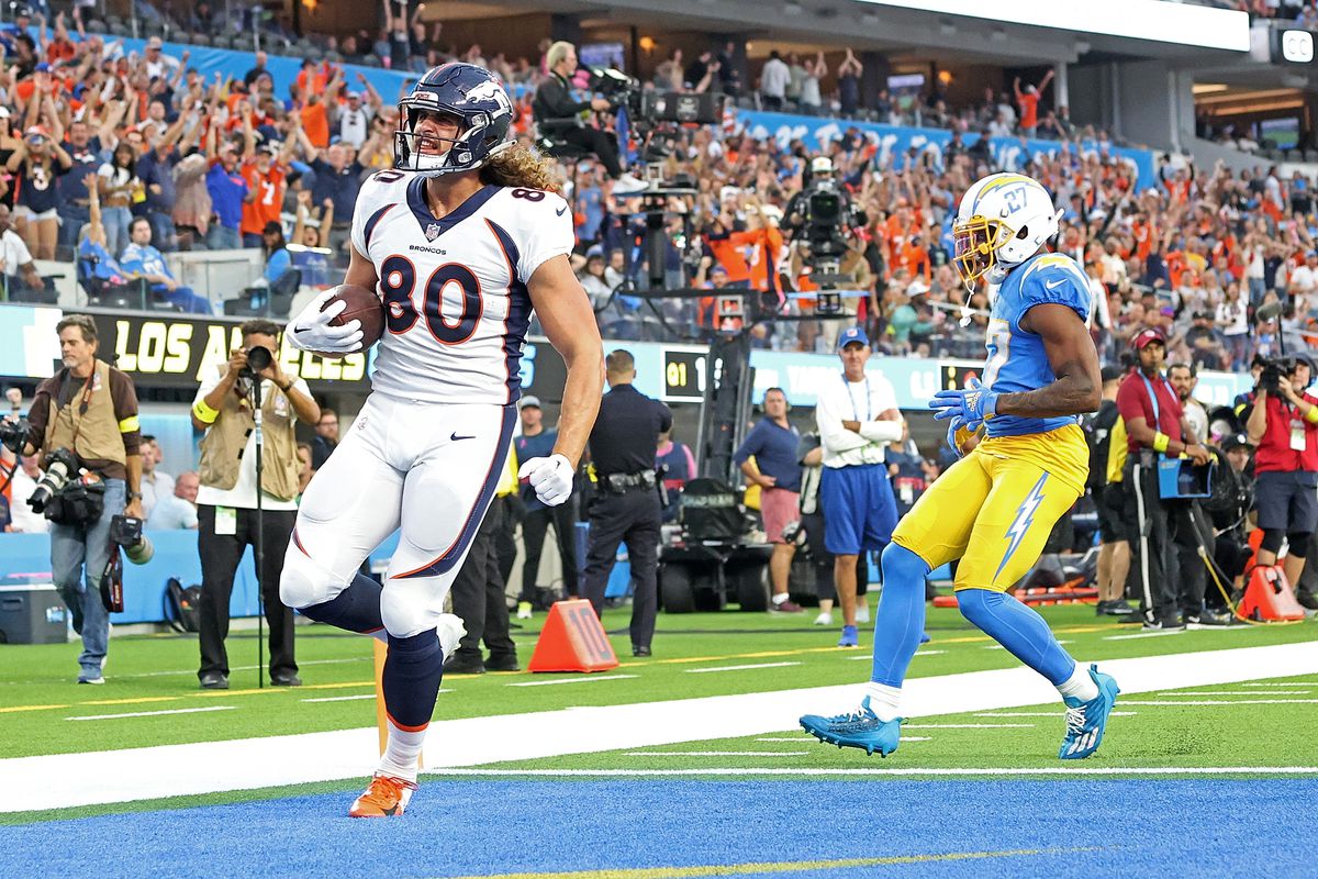 Greg Dulcich #80 of the Denver Broncos scores a touchdown in front of J.C. Jackson #27 of the Los Angeles Chargers during the first quarter at SoFi Stadium on October 17, 2022 in Inglewood, California.