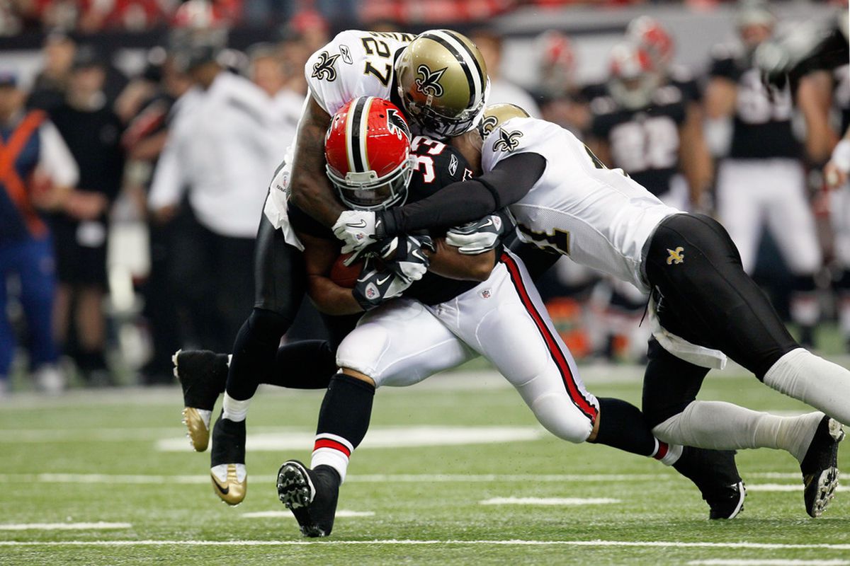 ATLANTA, GA - NOVEMBER 13:  Michael Turner #33 of the Atlanta Falcons is tackled by Malcolm Jenkins #27 of the New Orleans Saints and Roman Harper #41 at Georgia Dome on November 13, 2011 in Atlanta, Georgia.  (Photo by Kevin C. Cox/Getty Images)