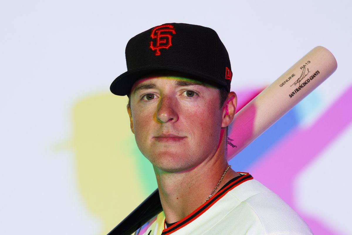 Tyler Fitzgerald holding a bat on his shoulders, surrounded by cool lights at photo day
