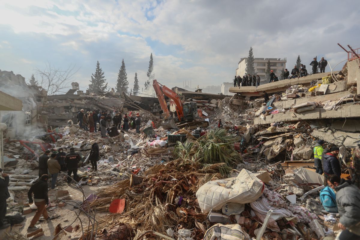 Ağır makine, 10 Şubat 2023'te Kahramanmaraş, Türkiye'de çöken bir binanın molozunu karıştırıyor.