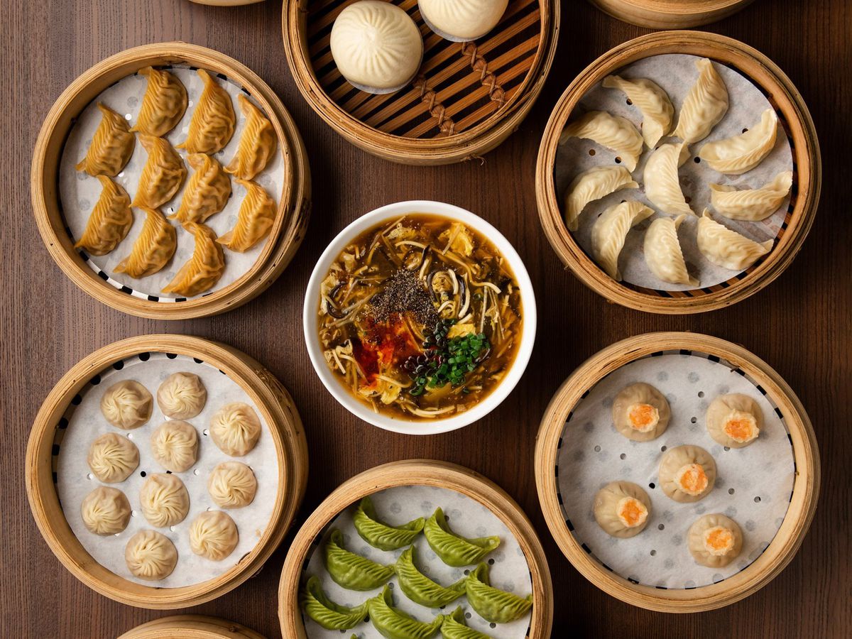 An overhead view of a many baskets of dumplings on a table.