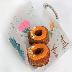 Inside each box lies two pumpkin cream Cronuts™ sprinkled with gold leaf. [<a href="http://www.refinery29.com/2013/11/57429/cronut-mission-celebrity-fundraiser">Photo</a>]