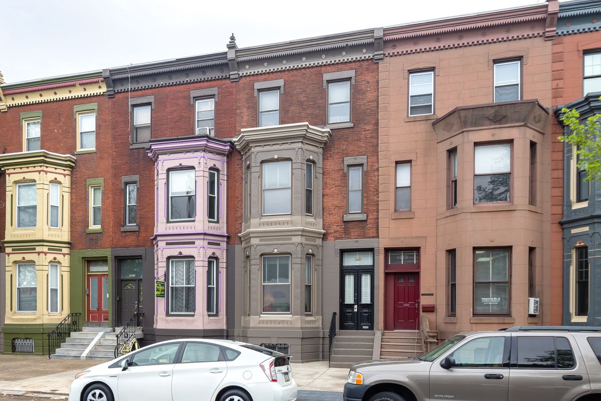 A series of colorful Victorians with bay windows in South Philly.