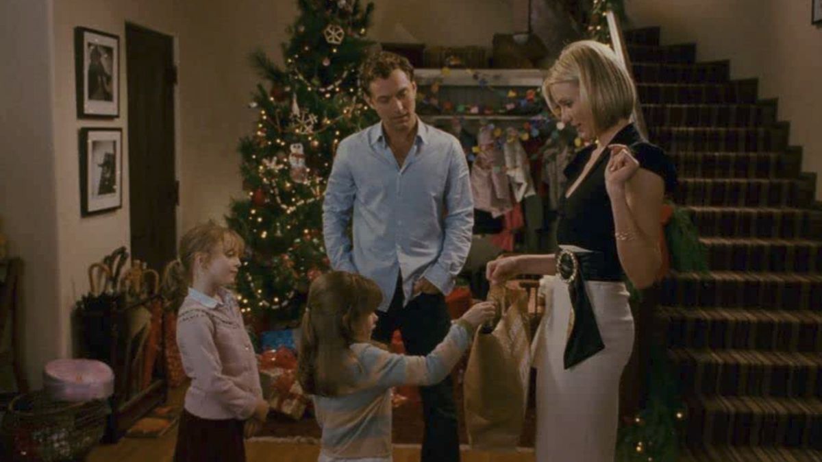 A woman, man, and two little girls in a holiday setting. One of the girls takes the woman’s bag.
