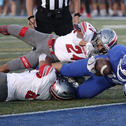 Bingham’s Saia Lomu scores a touchdown as he is tackled by Mountain Ridge’s Chase Leiataua (24) and DeMarco Brimmage (4) during a high school football game at Bingham High School in South Jordan on Friday, Sept. 24, 2021.