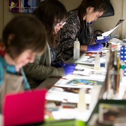 Irina Harding, Ashley Fairbourne and Katie Christiansen, left to right, paint art glass pieces that will be part of “The Roots of Knowledge,” a 200-foot-long stained glass installation for Utah Valley University, at Holdman Studios in Lehi on Friday, Nov. 4, 2016. The university announced a $1.5 million donation from philanthropists Marc and Deborah Bingham that will enable the completion of the massive stained glass installation.