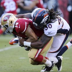  Denver Broncos strong safety David Bruton (30) tackles San Francisco 49ers wide receiver Chad Hall (14) on the return during the second quarter at Candlestick Park.