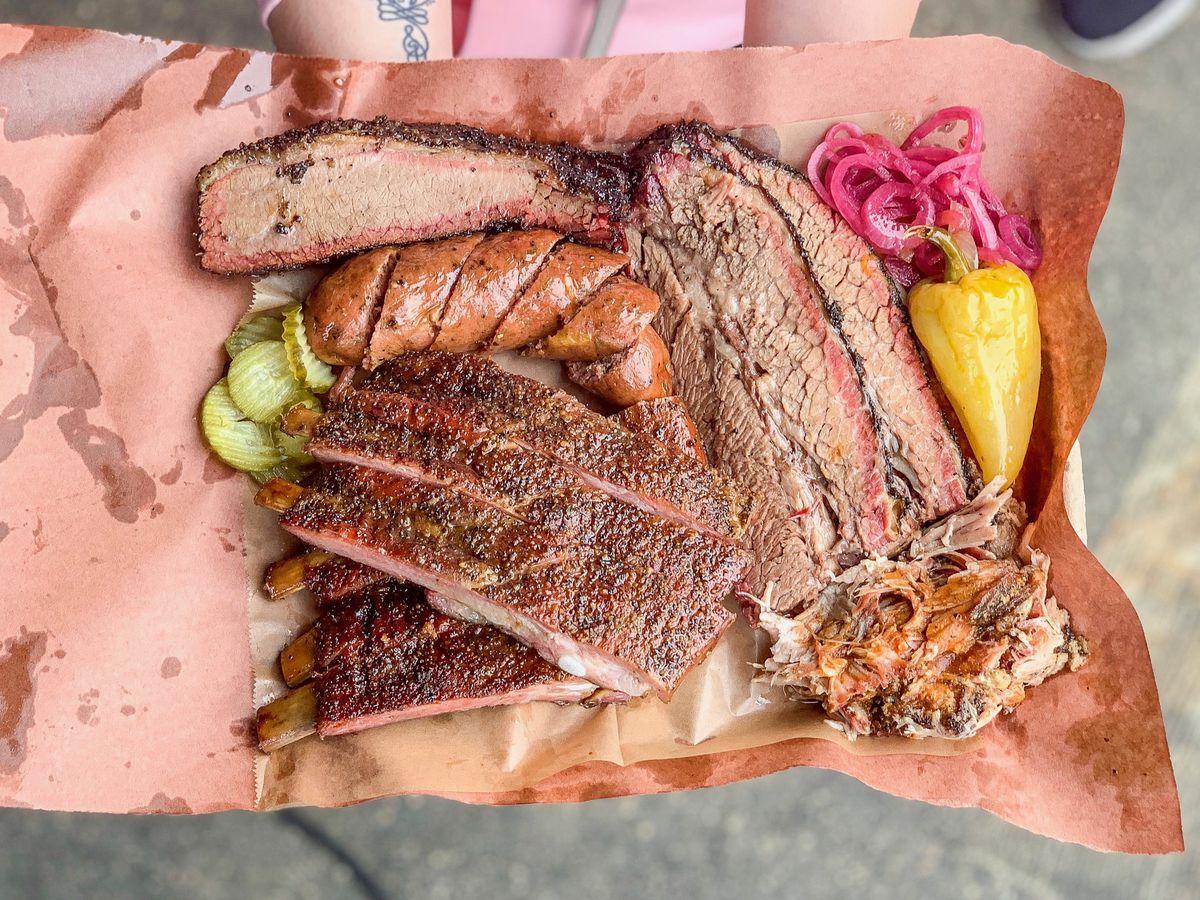 Moo’s craft barbecue sits on a pink paper tray.