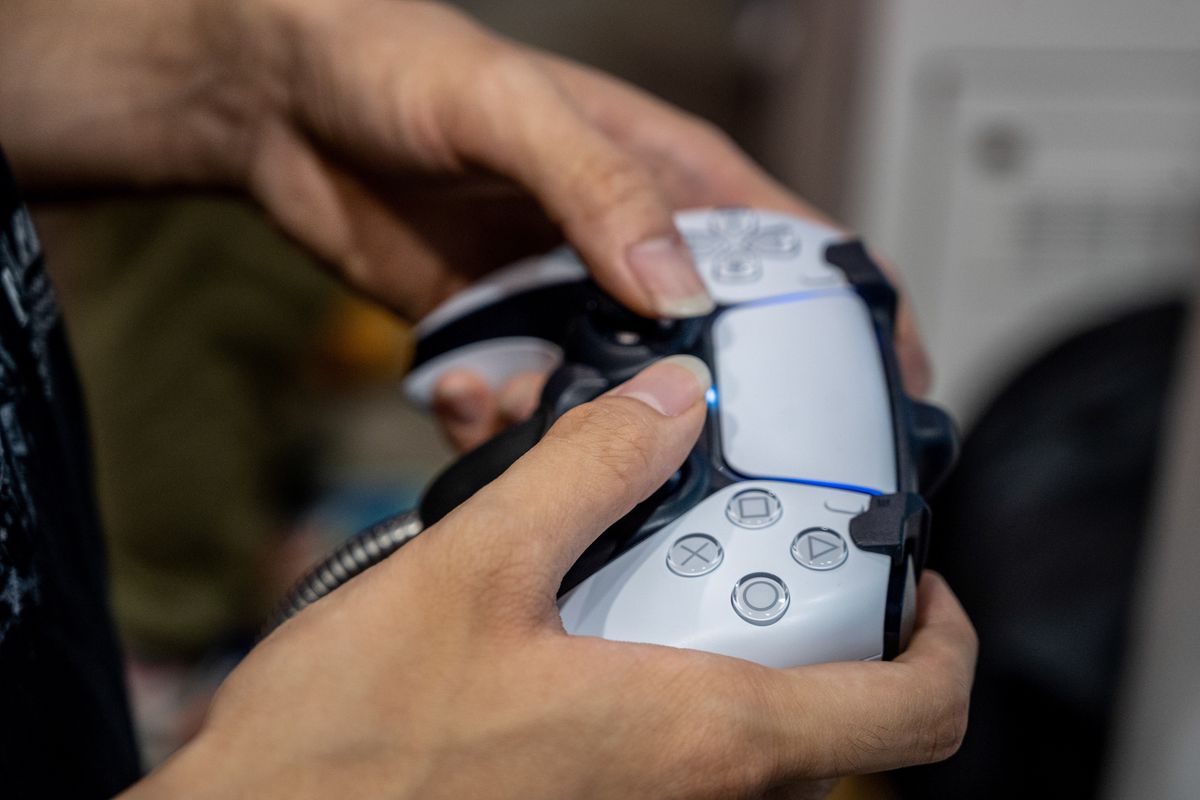 A visitor plays videogames using a controller from the...