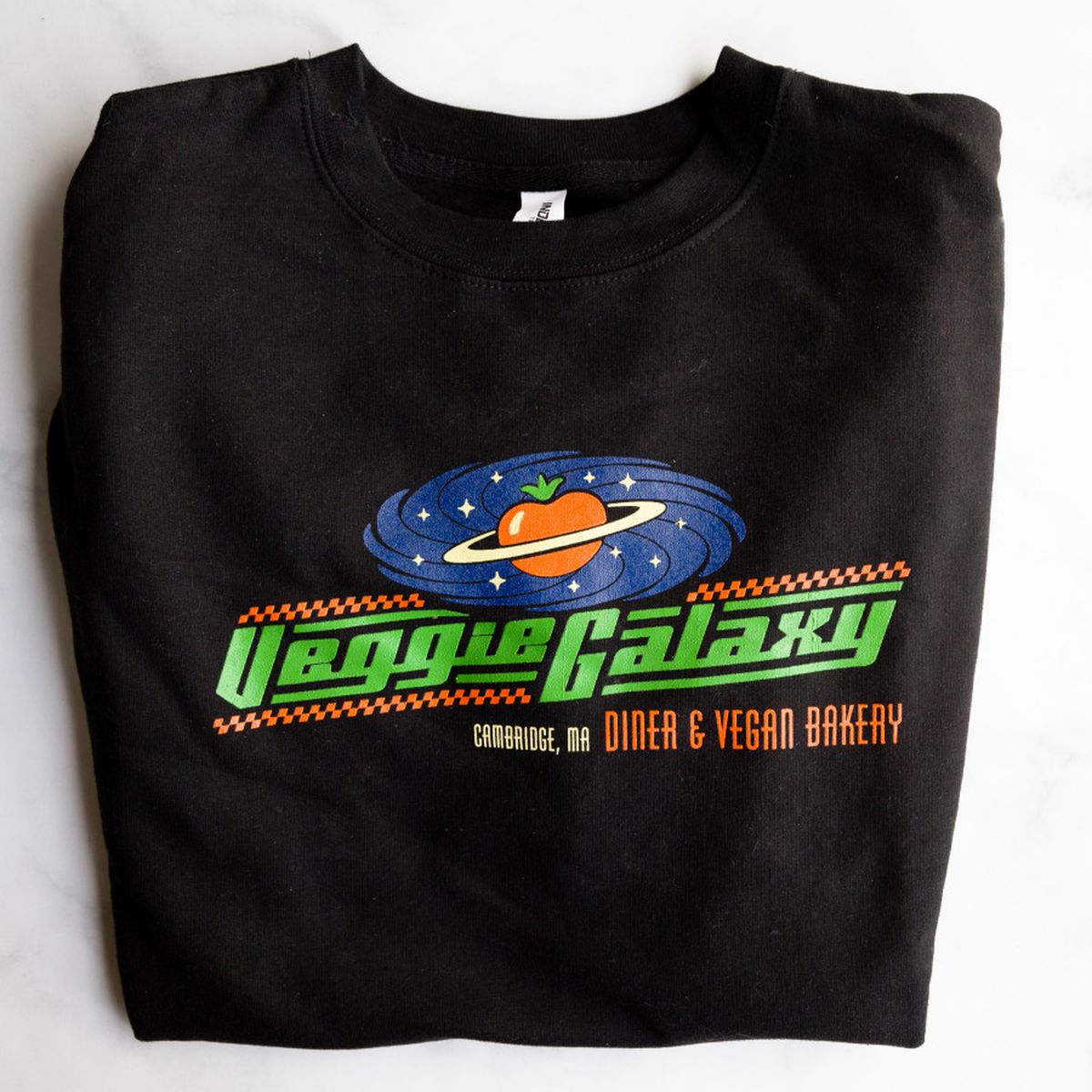 Black crewneck sweatshirt has large, colorful Veggie Galaxy design across the front