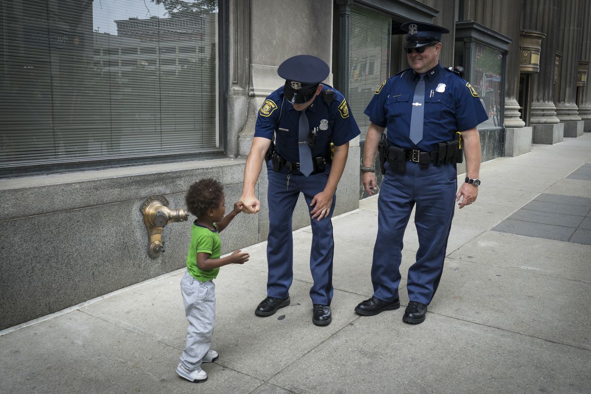 Jessie Cowe shares a fist bump with police officers during a protest on the first day of the 2016 Republican National Convention in Cleveland.
