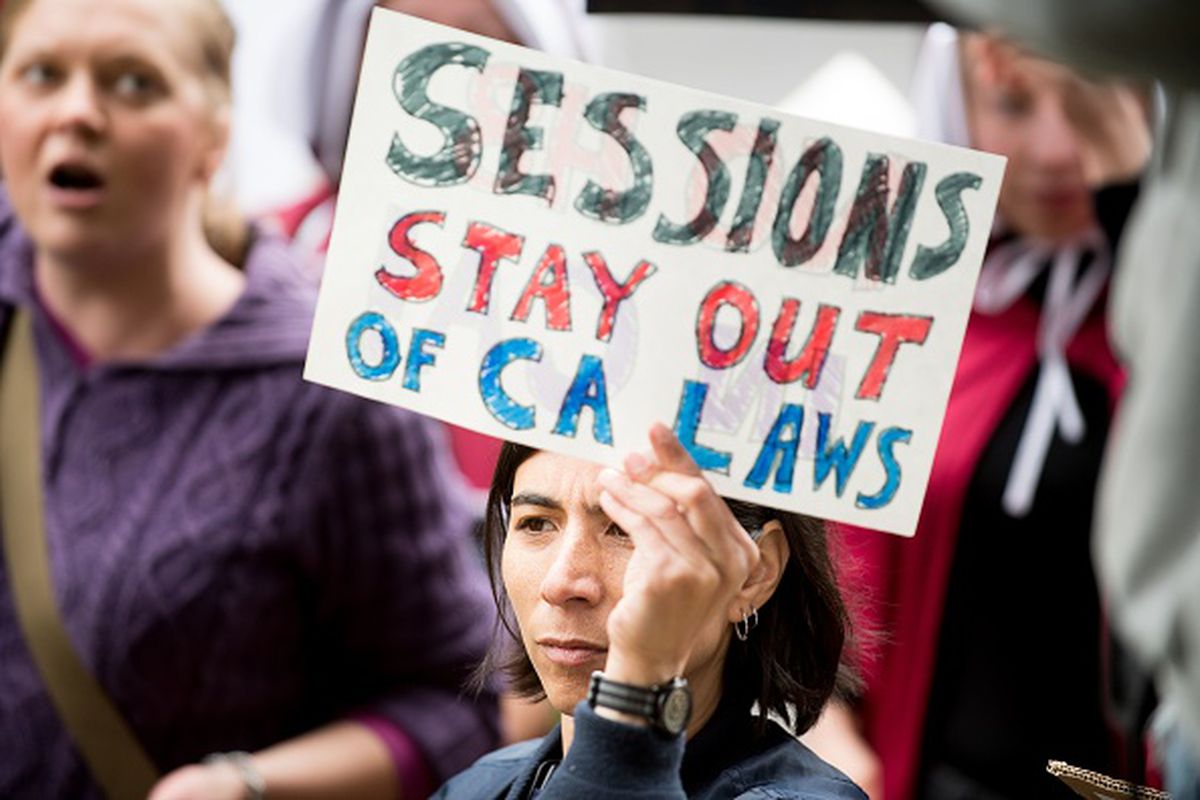 People protest outside a speech by US Attorney General Jeff Sessions March 7, 2018, in Sacramento, California. Sessions and the Department of Justice are suing California over its “sanctuary laws.”