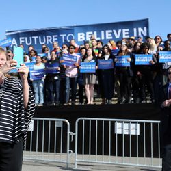 The wife of Democratic presidential candidate and Vermont Sen. Bernie Sanders, Jane, takes a photo with her phone while her husband gives a speech to supporters at This is the Place Heritage Park in Salt Lake City, Friday, March 18, 2016.