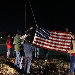 In this Tuesday, Feb. 4, 2014 photo, Trail Life members practice a flag raising ceremony during a nighttime meeting in North Richland Hills, Texas. Trail Life USA promotes itself on its website as the "premier national character development organization for young men which produces Godly and responsible husbands, fathers and citizens." 