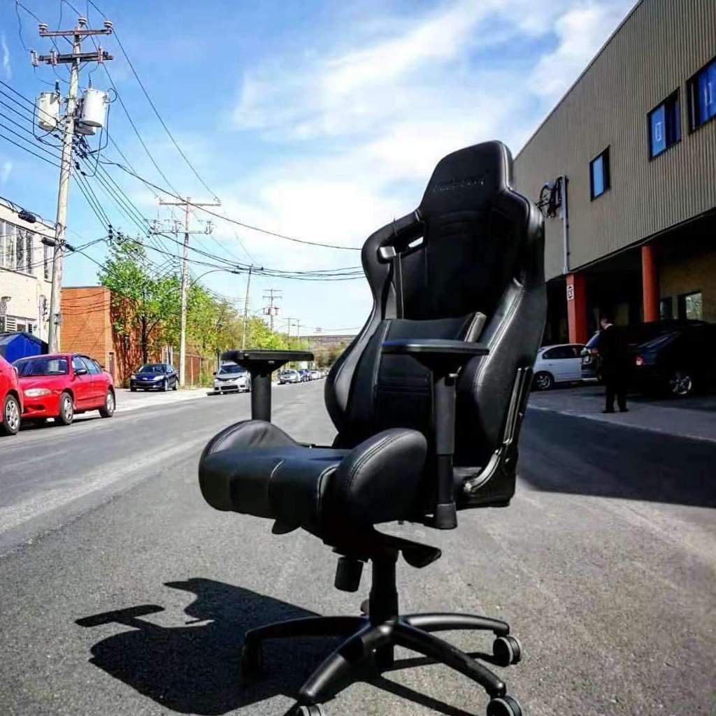 Anda Seat Dark Knight gaming chair sits empty in the middle of a street