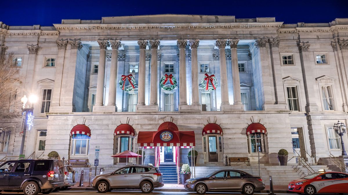 the exterior of Kimpton Hotel Monaco D.C. with ornate columns and large Christmas wreaths