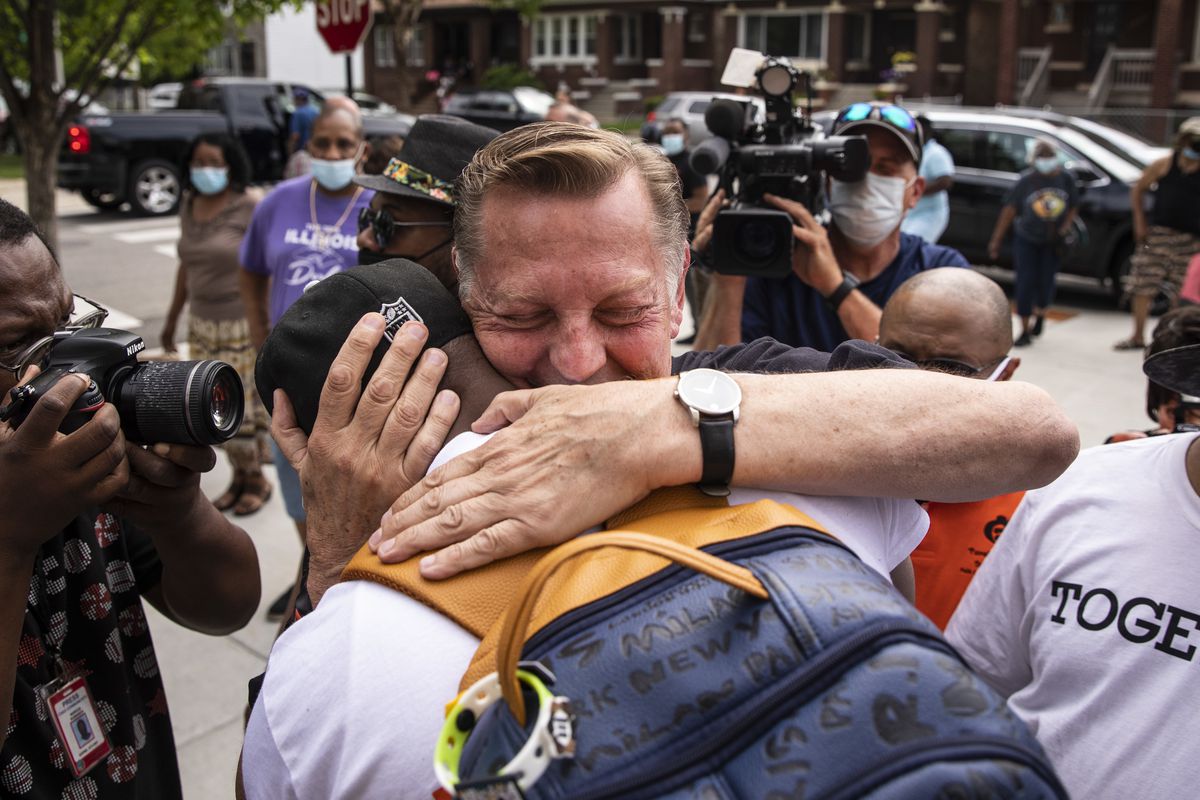 Father Michael Pfleger hugs a supporter outside St. Sabina Church Monday afternoon after the Chicago Archdioces announced that Pfleger will return to his role at  at the Auburn Gresham church.