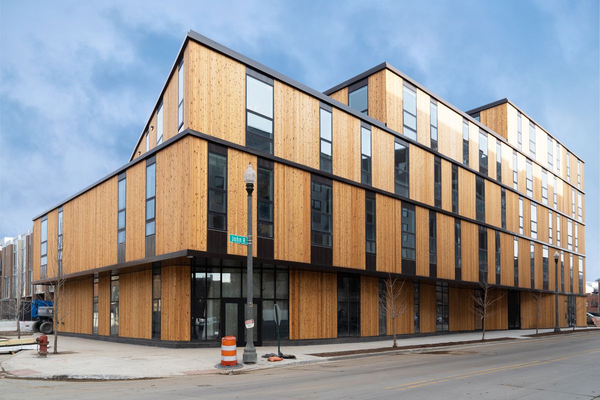 A four-story building with wood-cladding and narrow windows. It’s rectangular with each floor slightly smaller. 